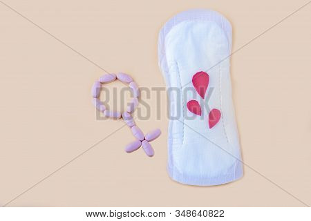 Protective Menstrual Pad And Gender Symbol Made From Pink Pain Pills. The Concept Of Women Gynecolog