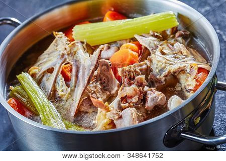 Cooked Chicken Stock With Vegetables And Aromatic Herbs In A Stockpot, Close-up, Horizontal From Abo