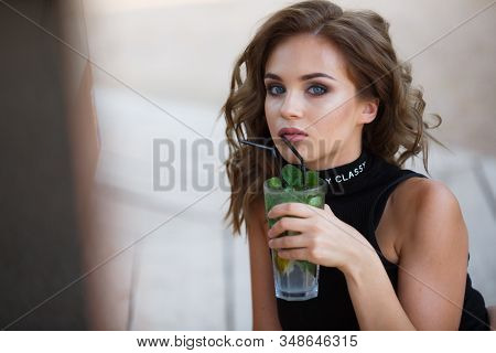 Beautiful Young Woman Enjoy Enjoys A Smoothie And Relax On Tropical Beach With Palm Tree. Summer Vac