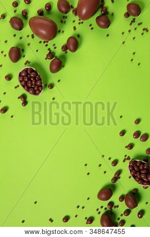 Egg Hunt Is Coming. Easter Traditions, Chocolate Eggs On Green Background, Top View, Copyspace For Y