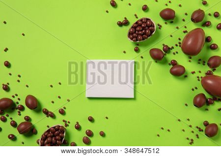 Egg Hunt Is Coming. Easter Traditions, Chocolate Eggs On Green Background, Top View, Copyspace For Y