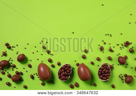 Egg Hunt Is Coming. Easter Traditions, Chocolate Eggs On Green Background, Top View, Copyspace For Y