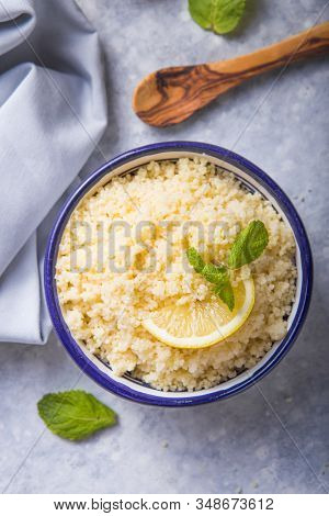 Couscous With Mint And Lemon In Plate On Dark Rustic Table From Above. Copy Space For Text. Flat Lay