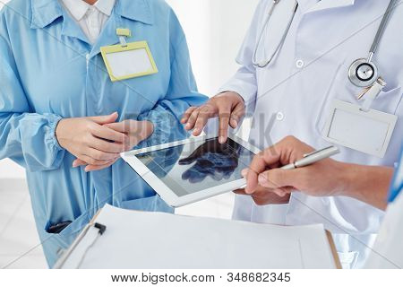 Group Of Physicians Checking Scull X-ray On Tablet Computer And Planning Surgery
