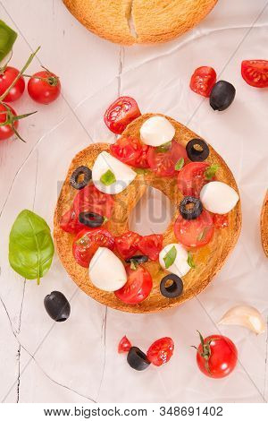 Friselle With Tomatoes And Mozzarella Cheese On Wooden Table.
