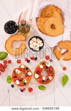 Friselle With Tomatoes And Mozzarella Cheese On Wooden Table.