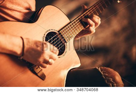 Caucasian Singer Musician With Classic Acoustic Guitar. Guitar Ballad Playing Closeup Photo.