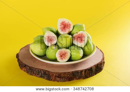 Ripe Sweet Green Figs On A Plate. Healthy Mediterranean Fig Fruit On A Yellow Background, Made In Pu