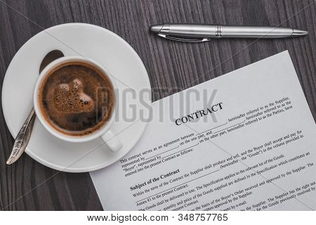 Contract Signing Concept, Close-up Cup Of Coffee, Silver Pen And Empty Paper Sheet Of Agreement Betw