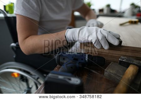 Man Sits In A Wheelchair And Works As Carpenter. Small Business For Disabled People Training Study C