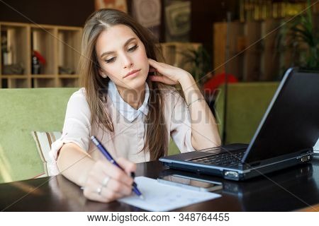 The Girl In The Cafe Makes An Entry In The Diary. Drawing Up Or Updating The Work Schedule. Woman Ha