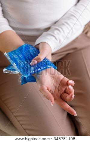 Close Up Of Woman Applying Cold Compress To A Her Painful Wrist Caused By Prolonged Work On The Comp