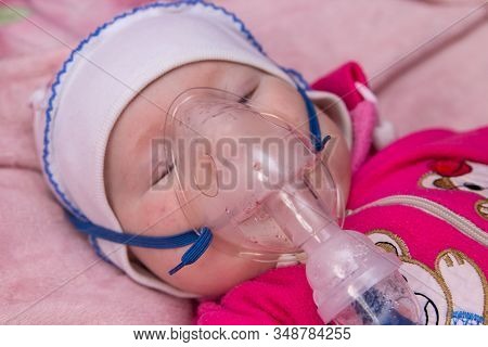 Treatment Of Infant From Nebulizer Virus, The Baby Lies And Breathes Through The Mask Of An Inhaler,