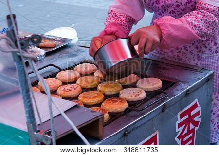 China, Heihe, July 2019: A Woman Prepares Pancakes At A Street Market In Heihe In The Summer