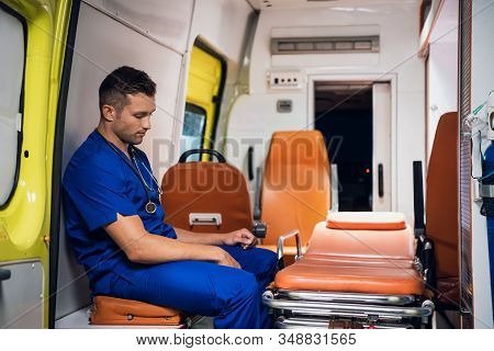 Corpsman In Uniform Sits Inside The Ambulance Car And Think