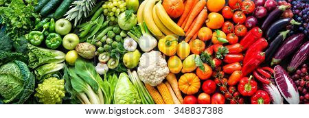 Panoramic food background with assortment of fresh organic fruits and vegetables in rainbow colors
