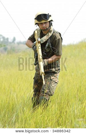 junger Soldat im Helm mit einer Pistole