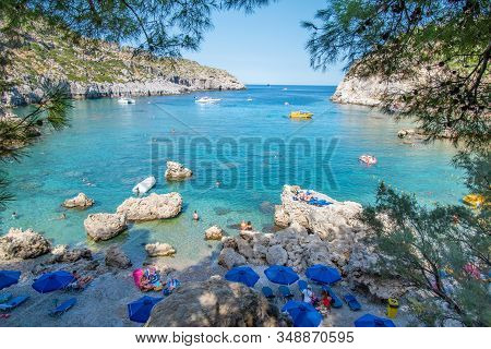 Small Beach With Tourists, Umbrellas And Sun Chairs In Anthony Quinn Bay (rhodes, Greece)