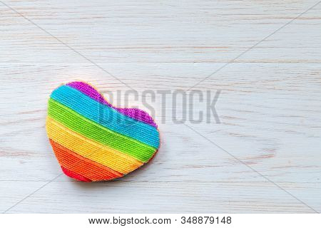 One Rainbow Heart Shape Pillow On White Painted Vintage Wooden Background. Symbol Of Homosexual Love