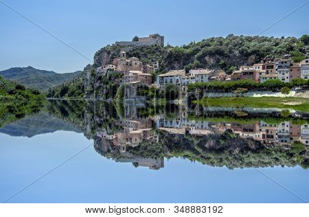 Reflections In The Ebro Of The Town Of Miravet In Tarragona