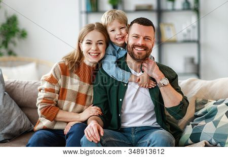 Happy Family Mother Father And Kid Son At Home On The Couch