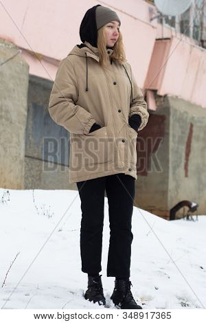 Teenage Girl Standing Near Building In The Snowtime