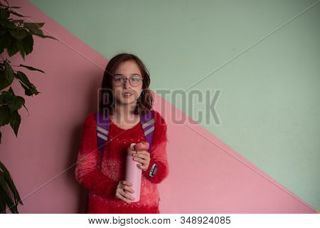 Girl With Cup. Schoolgirl Girl In Glasses Drinks Water From A Thermomug.a Schoolgirl Drinks Tea, Jui