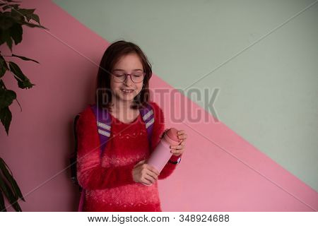 Girl With Cup. Schoolgirl Girl In Glasses Drinks Water From A Thermomug.a Schoolgirl Drinks Tea, Jui