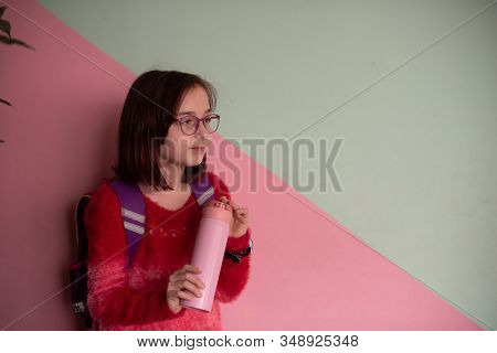 Girl With Cup. Schoolgirl Girl In Glasses Drinks Water From A Thermomug.a Schoolgirl Drinks Tea, Jui