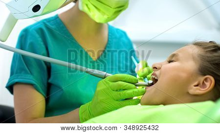 Lady Stomatologist Polishing Little Girls Tooth Enamel, Oral Cavity Protection