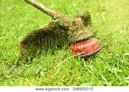 Trimmer Close Up Mow The Grass With A Lawnmower. Gardening With A Brush Cutter Close-up. Lawn Care W