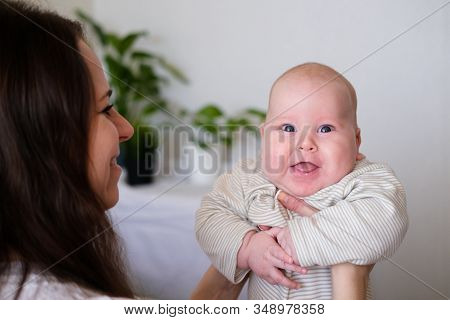 Happy Baby. Little Cutest Chubby Caucasian White Infant Child Looking And Smiling At Camera On Mothe