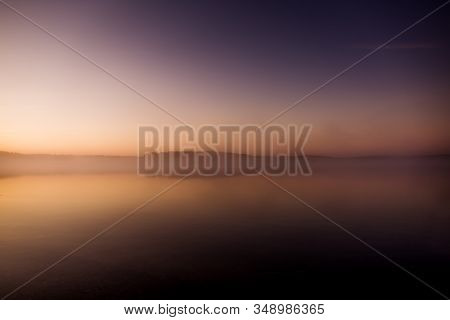 Early Morning On The Lake With A Pink Dawn And Shrouded Haze Of Mist, A Mesmerizing Mysticism Of Nat