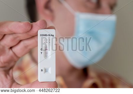Man Wearing Face Mask Holding Covid-19 Rapid Antigen Test Cassette With Negative Result Of Rapid Dia