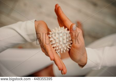 Athletic Slim Caucasian Woman Doing Thigh Self-massage With A Massage Ball Indoors. Self-isolating M