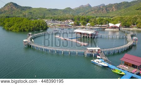 Aerial View Of Pedestrian Bridge Over Sea. Narrow Wooden Bridge With Beautiful Seafloor And Reflecti
