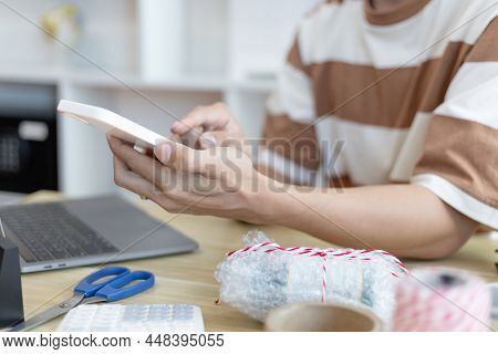 Young man selling products online was chat on the phone to receive an order from a customer and wrot