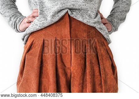 A White Woman Stands In Front, Hands On Her Waist, Wearing A Knitted Jumper And Corduroy Trousers. D