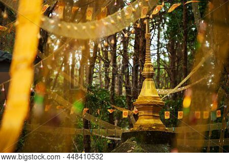Golden Pagoda And Dharmacakra Flags In A Deep Forest, Symbol Of Buddhism In Thailand.