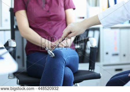 Neurologist Examines Patient And Taps Leg With Hammer. Pathological Reflexes Concept