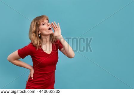 Young Woman Put Her Hand To Face And Shout To Someone Isolated On Blue Background. Copy, Empty Space