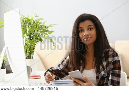Portrait Of Lovely Latin Woman On Workplace, Write In Notebook, Computer Device On Desk. First Worki