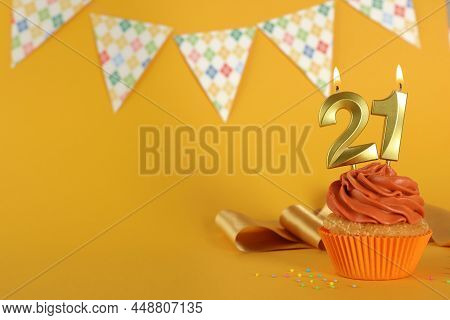 Coming Of Age Party - 21th Birthday. Delicious Cupcake With Number Shaped Candles On Orange Backgrou