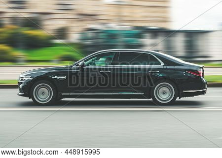 Genesis G90 Car In The City Street. Black Premium Korean Car With Man Driver Is Moving On The Speedw