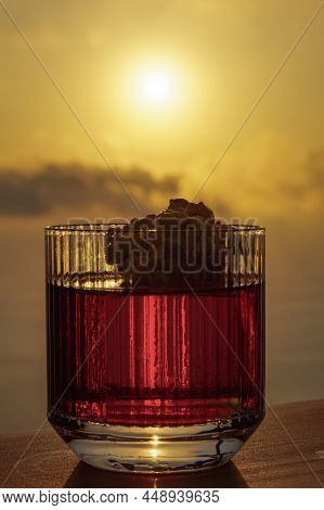 Negroni Cocktail In An Old-fashioned Garnished Glass Against Orange Sunset. Italian Alcoholic Aperit