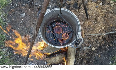 Mulled Wine In A Tourist Pot Over Hot Camp Fire. Mulled Wine By The Fire. Mulled Wine Cooked On Fire