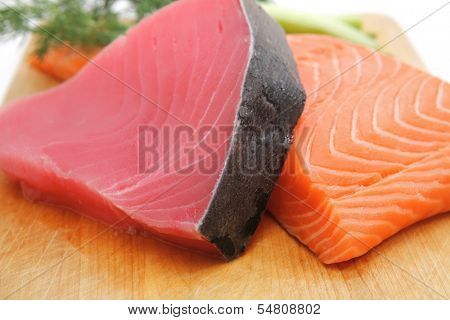 fresh raw salmon and tuna fish  pieces on wooden plate isolated on white background