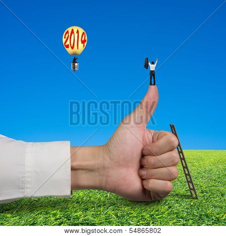 Businessman Standing On Top Of Thumb, Another In Balloon With 2014