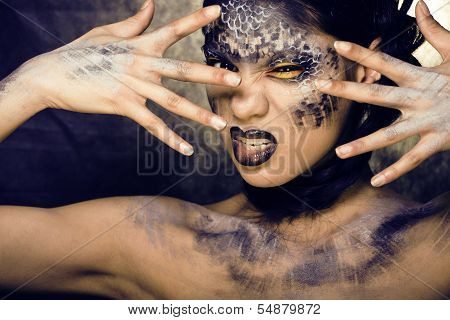 fashion portrait of pretty young woman with creative make up like a snake
