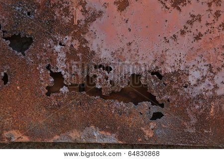 Brown paint on metal wall with corrosion.